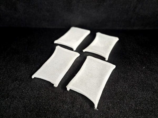 Four white rectangular fabric pouches FF-5 for 5/8″ (1.58 CM) TO 1-1/4″ (3.2 CM) are evenly spaced on a black surface.