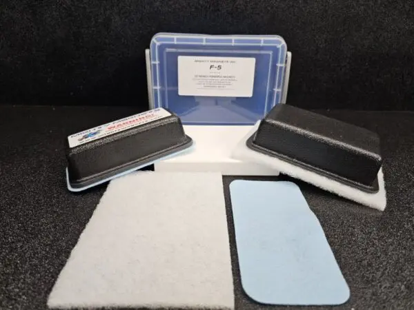 A kit containing a black foam grip tool, a blue rectangular pad, a white rectangular pad, and a clear plastic storage case labeled "F-4 for 1/2″ (1.3 cm) to 1″ (2.5 cm).
