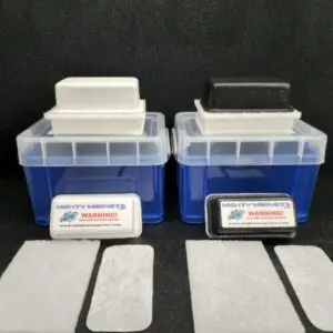 Two blue containers with clear lids, each holding a small block, sit side by side. In front of each container, there are three rectangular white pads and a magnet labeled "F-6 for 1″ (2.5 cm) to 1-1/2″ (3.8 cm).