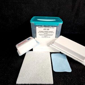A blue-lidded plastic container labeled "FF-5 for 5/8″ (1.58 CM) TO 1-1/4″ (3.2 CM)" is accompanied by various cleaning pads and a small blue cloth, laid out on a dark surface.