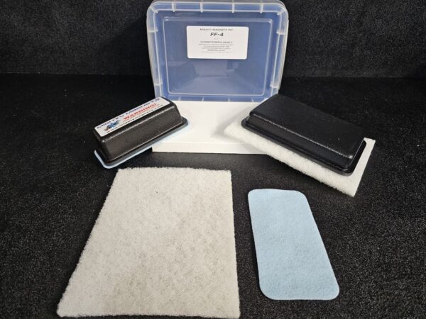 A plastic container labeled "FF-3 for 3/8″ (.95 CM) TO 3/4″ (1.9 CM)" is open, revealing various types of filters, including foam and blue material, arranged on a black surface.