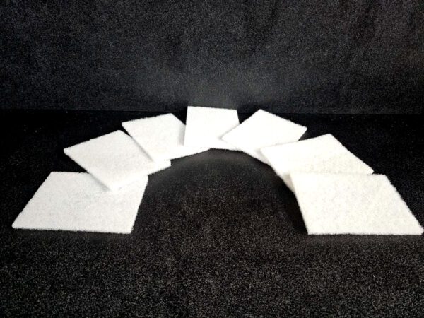 Seven white Scrub Pads (A) are arranged in a slight arc against a black background.