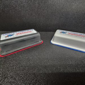 Two magnetic erasers on dark surface.